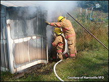 Harrisville firemen gain entrance to a meter house fire.